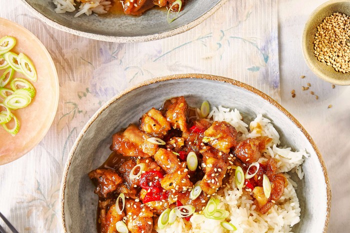 Two bowls of sticky chicken with rice