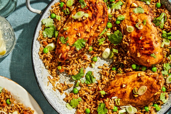Healthy one-pan chicken and rice A Large Pan of Brown Rice Topped with Chicken Breasts and Spring Onions