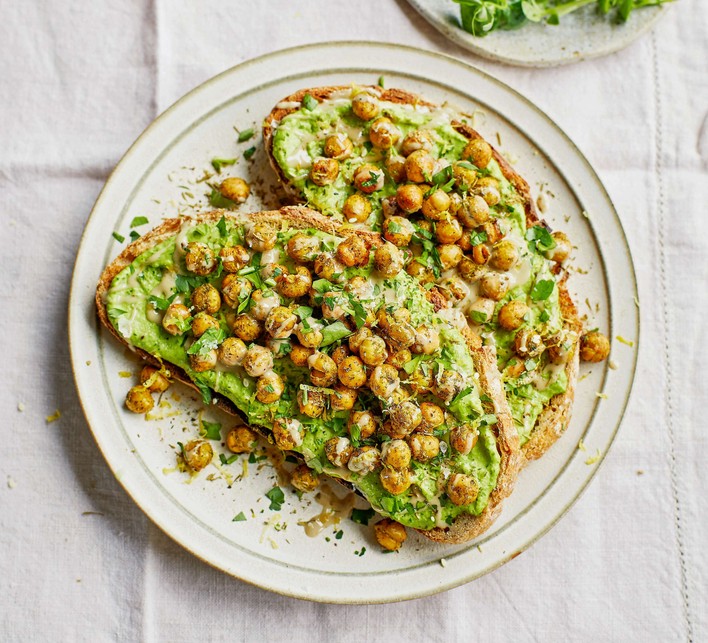 Crispy chickpeas on green toast Two slices of chickpeas on toast on a white plate