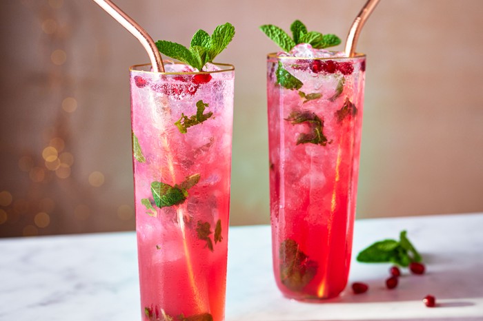 Christmas mojito Two glasses of pink-hued mojito with mint and metal straws