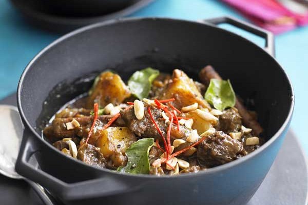 Beef Massaman Curry Recipe Bowl of beef massaman curry on a plate with a spoon
