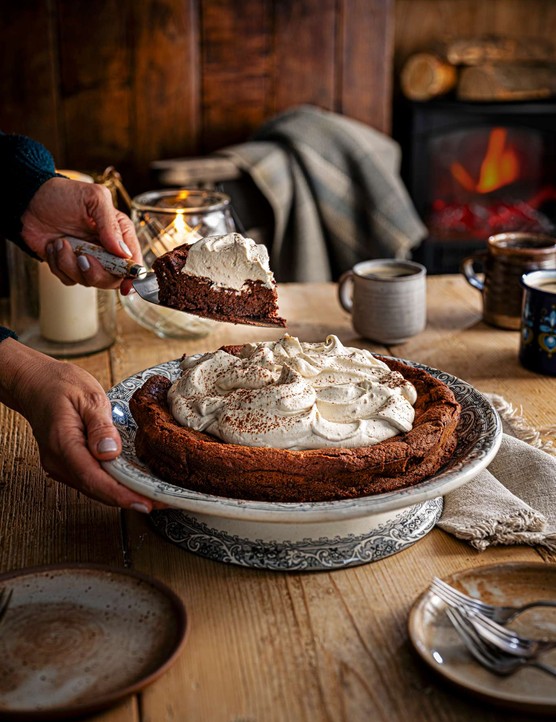A large chocolate cake with cream on top