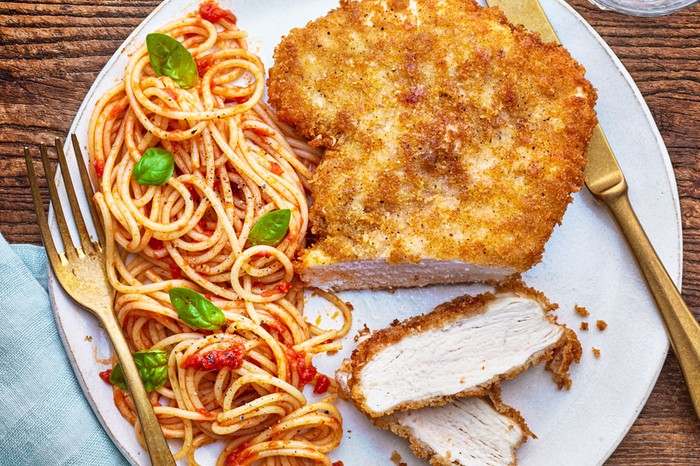 Chicken milanese Chicken milanese served with spaghetti pomodoro