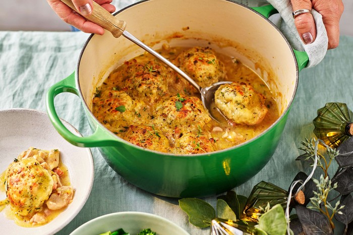 Chicken stew with parmesan dumplings Chicken casserole in a green dish with a serving plate