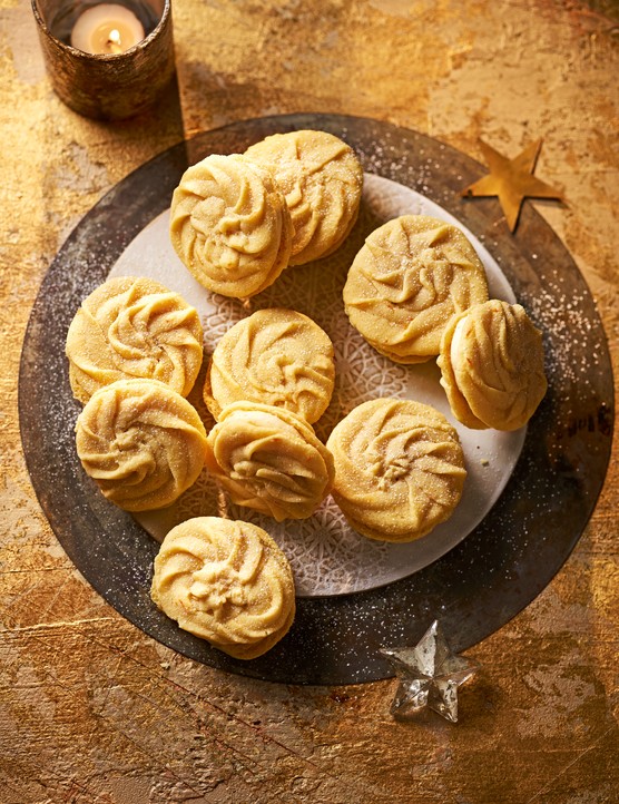 A plate topped with buttery swirl biscuits and filled with a ginger buttercream
