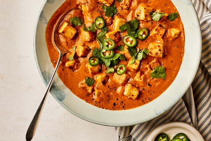 Creamy tofu curry with big veg sauce Bowl of tofu curry topped with chilli and coriander