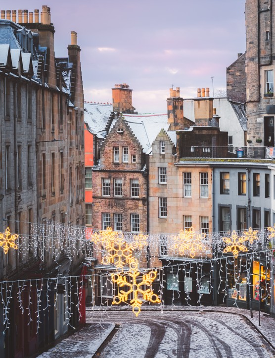 Winter in Edinburgh, Scotland Christmas decorations and the colourful shopfronts of Victoria Street in Edinburgh's old town on a winter morning after a fresh overnight snowfall.