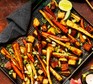 Gochujang-roasted root veg A tray of Gochujang-roasted root veg with a black kitchen cloth