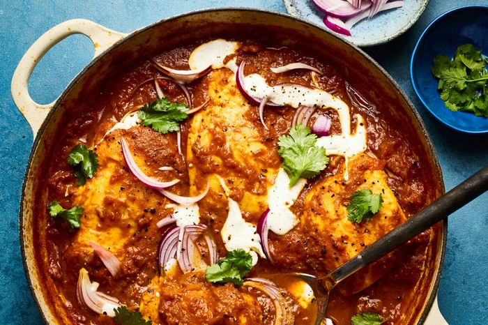 Halibut with smoky masala sauce A large dish of fish masala with condiments on the side