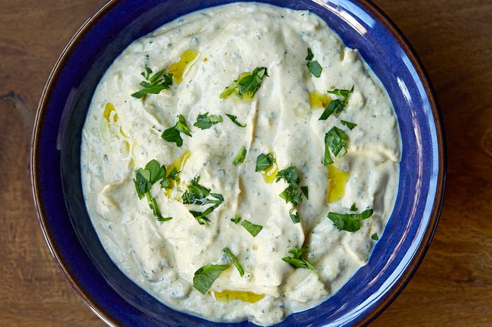 Avocado tzatziki A blue bowl filled with a yogurt and cucumber dip