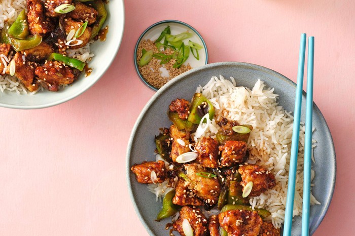 Kung-pao style tofu in a bowl with blue chopsticks