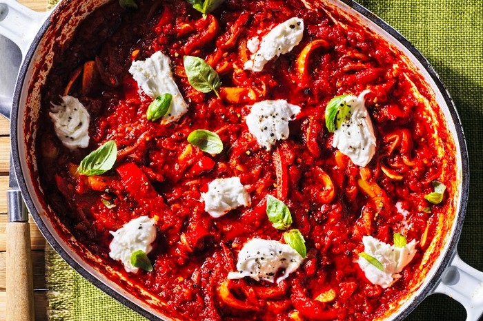 ’Nduja pepperonata stew An oven dish flled with a red stew, topped with torn mozzarella next to a basket of bread