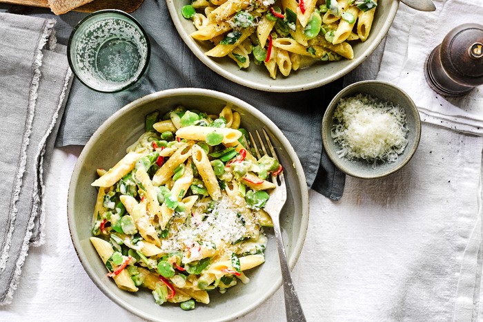Broad bean, mint and chilli pasta A bowl of pasta with broad beans and sliced chilli on a white linen tablecloth