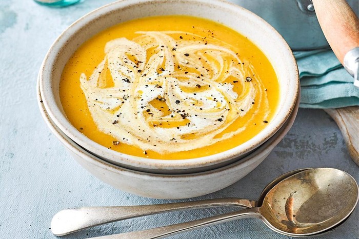 Carrot and Parsnip Soup Recipe Carrot and parsnip soup in a white bowl next to spoon