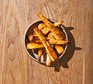 Roast parsnips with black seed honey A bowl of roast parsnips drizzled with honey