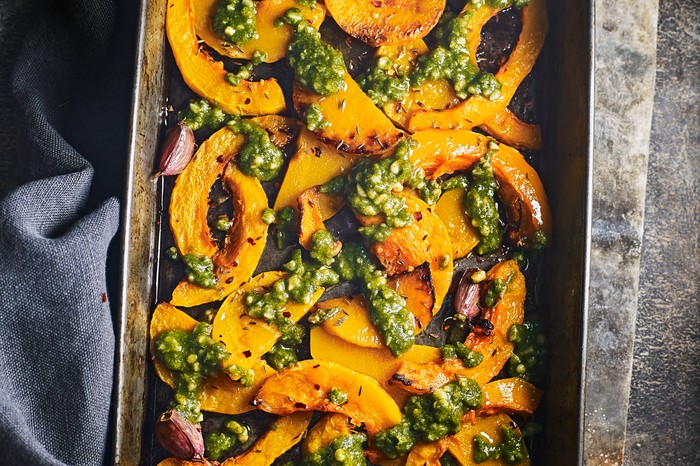 Roasted butternut squash with pesto Roasted butternut squash wedges with pesto on a baking tray