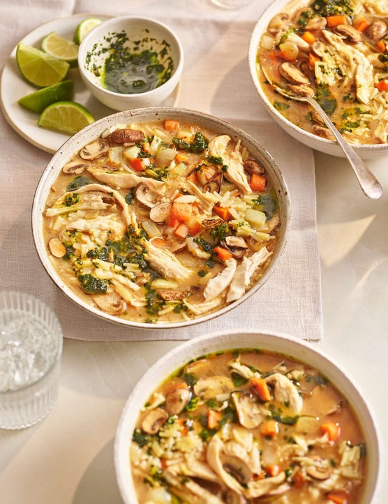 Two bowls of chicken soup on a set table