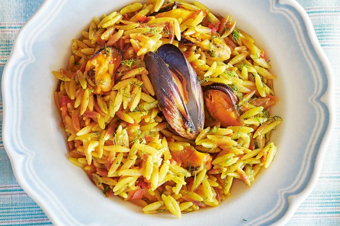 Orzo with mussels, saffron and ouzo Plate of orzo with mussels topped with a mussel in a shell