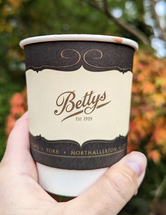 Bettys Harlow Carr Tea Room, Harrogate Bettys hot chocolate in a takeaway cup against autumnal trees