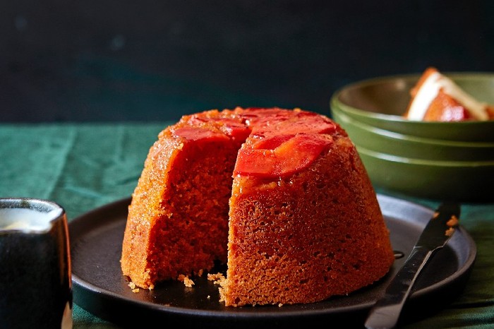 Quince pudding A steamed quince pudding on a black plate on a green linen table cloth