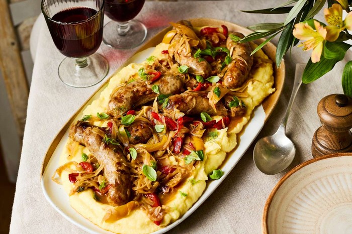 Braised Italian sausages with peppers, fennel and creamy parmesan polenta A platter of sausages and polenta