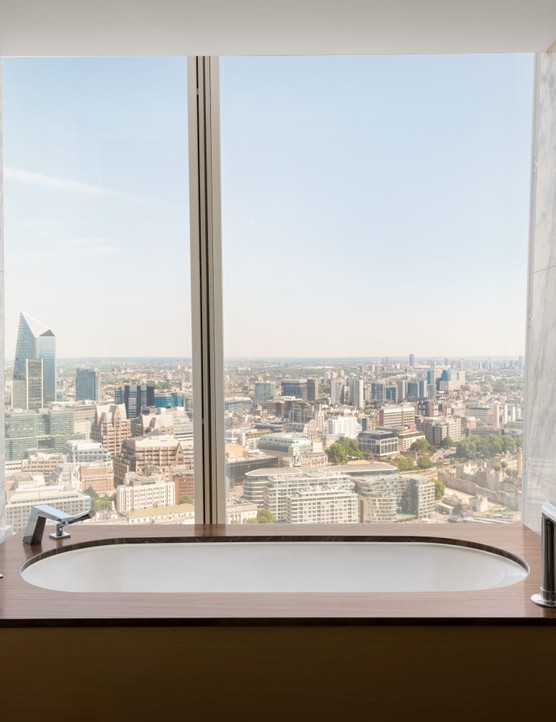 Shangri-La Hotel At The Shard London A bathtub in a hotel room which has a glass window looking out over London