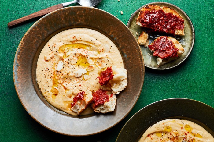 Roast parsnip soup A bowl of parsnip soup with a spoon and toast on the side
