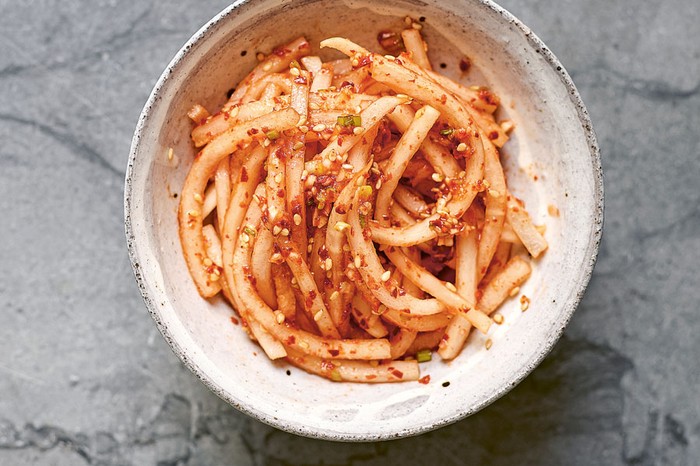 Korean spicy radish salad Bowl of julienned radishes topped with sesame seeds