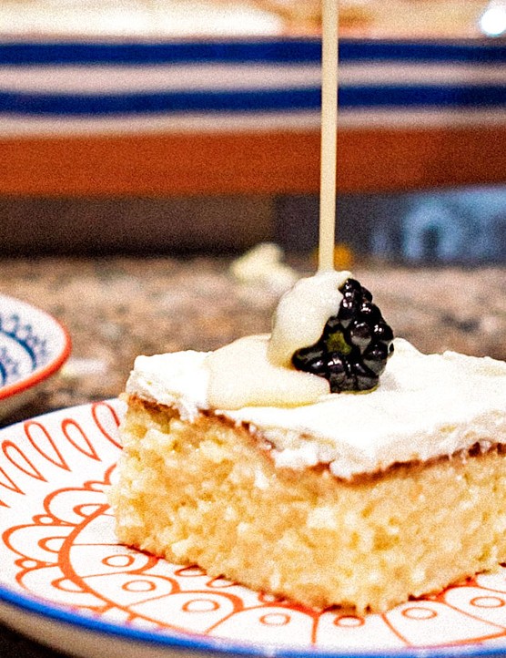 Tres leches cake with sauce being poured over