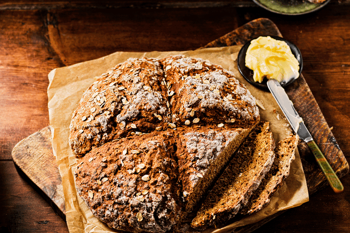 Round loaf of soda bread with butter on the side