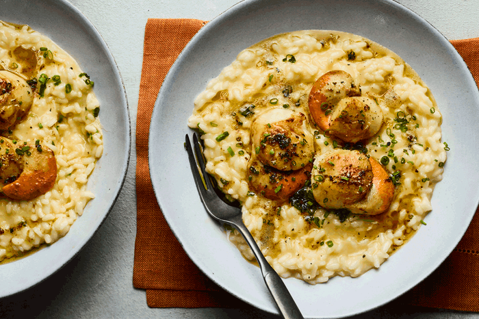 Scallop risotto Two bowls of creamy risotto topped with scallops
