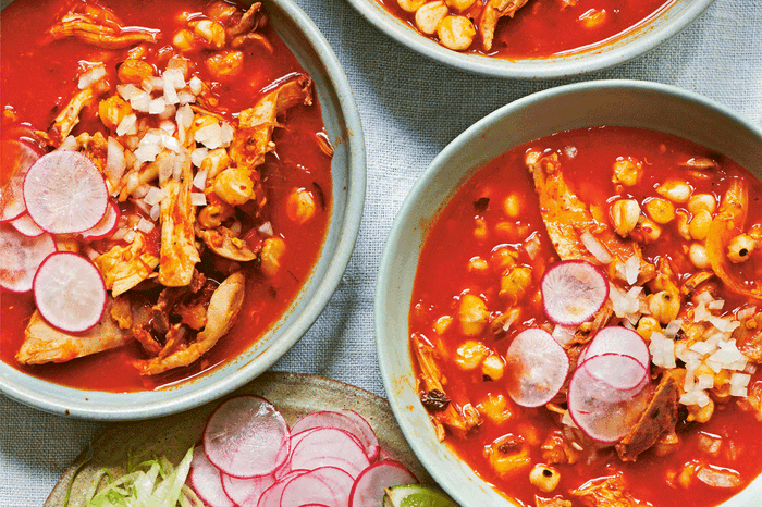 Chicken red hominy soup (Pozole rojo de pollo) Chicken red hominy soup (Pozole rojo de pollo) in bowls on a table