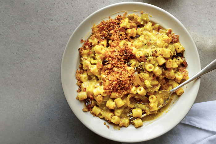 Sicilian pasta with cauliflower A large white bowl of pasta on a grey stone background with a white linen napkin